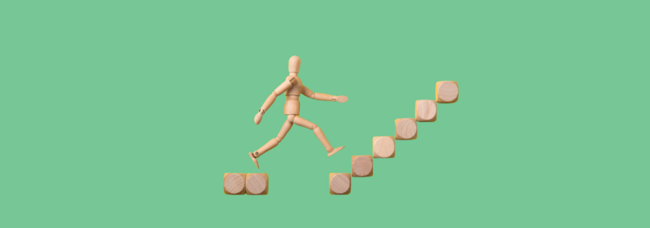 A green background with a wooden figure walking up stairs