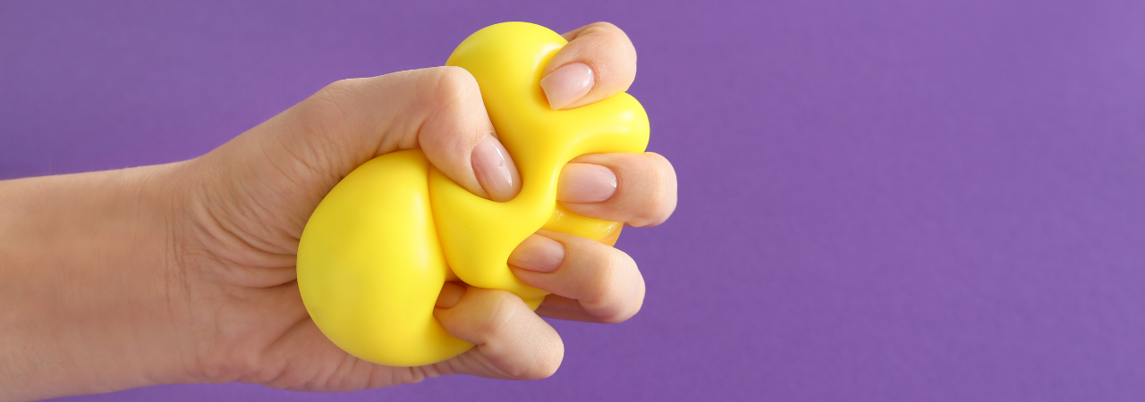 A purple background with a hand squeezing a yellow stress ball for stress awareness month