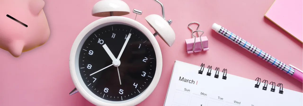 flatlay of alarm clock, calendar, and piggy bank
