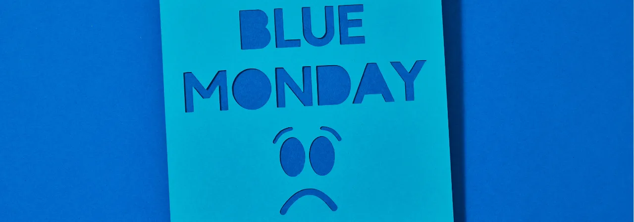 A blue background with a note in the middle which as the title blog "Blue monday" and a sad frowning face