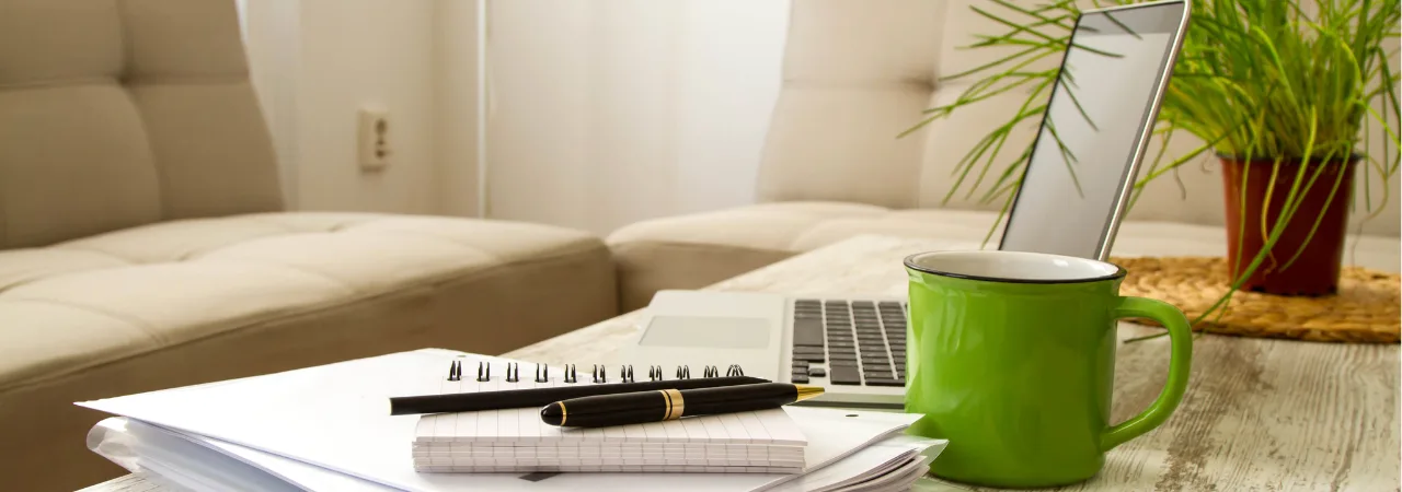 an image of a lounge and coffee table with notebooks and coffee