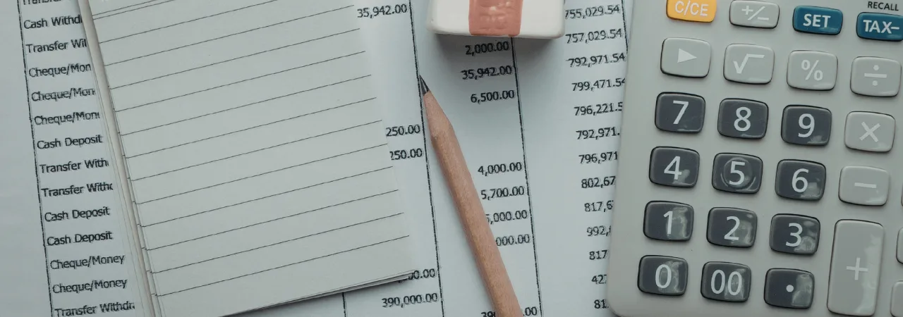 A Flatlay of a notebook, calculator and expenses
